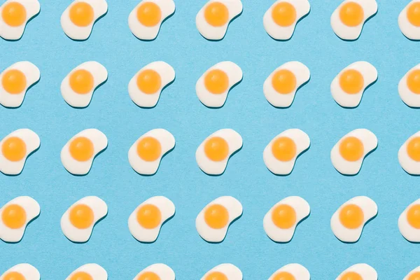 Top view of tasty gummy candies in shape of fried eggs on blue — Stock Photo