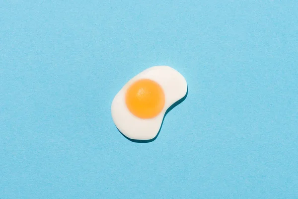 Вид сверху на желейные конфеты в форме жареного яйца на голубом — стоковое фото