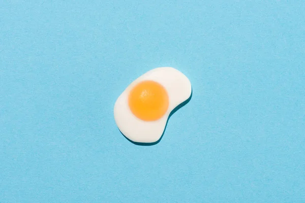 Vista superior de doces de goma em forma de ovo frito no azul — Fotografia de Stock