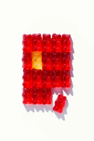 Vista superior del rectángulo rojo desfragmentado de ositos de goma sobre blanco - foto de stock