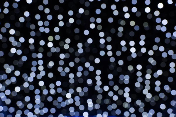 Nahaufnahme von blauen Bokeh-Lichtern auf schwarzem Hintergrund — Stockfoto
