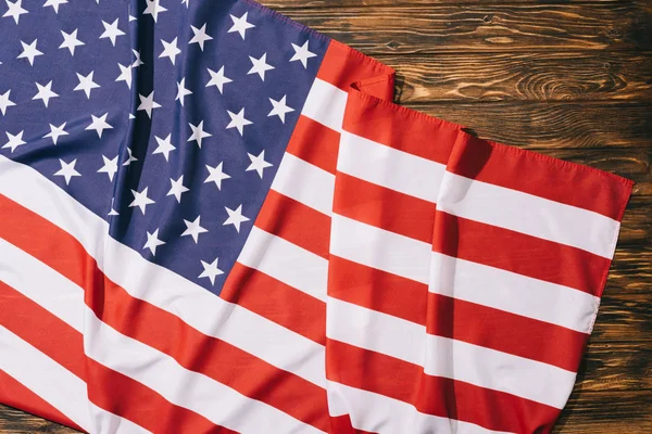 Draufsicht auf gefaltete amerikanische Flagge auf Holztischplatte, Konzept zum Unabhängigkeitstag Amerikas — Stockfoto