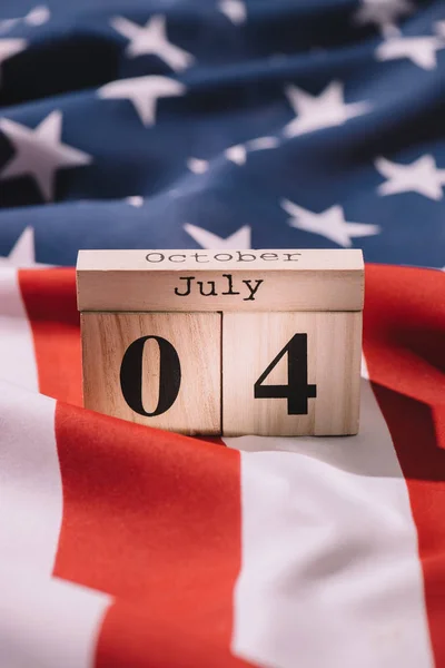 Vista ravvicinata del calendario in legno con data 4 luglio sulla bandiera americana, concetto di indipendenza americana — Foto stock