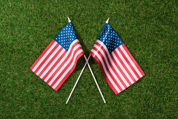 Top view of arranged american flagpoles on green grass, 4th july holiday concept — Stock Photo