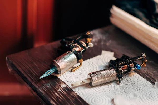 Close up view of tattoo machines on wooden tabletop at tattoo salon — Stock Photo