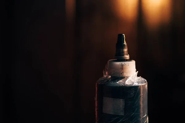 Close up view of bottle with tattoo paint with blurred background — Stock Photo