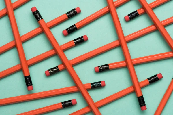 Vista dall'alto di matite disposte in grafite rossa con cancellini su verde — Foto stock