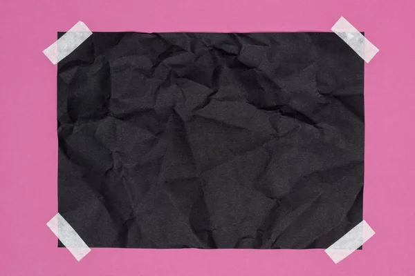 Top view of blank crumpled black paper on pink — Stock Photo