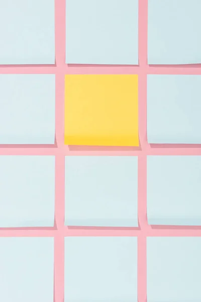 Elevated view of empty blue and yellow stick it notes on pink — Stock Photo