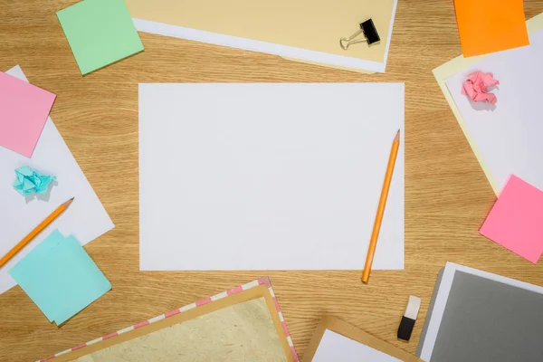 Blick auf leere Papiere mit Bleistiften und Schreibwaren auf Holztisch — Stockfoto
