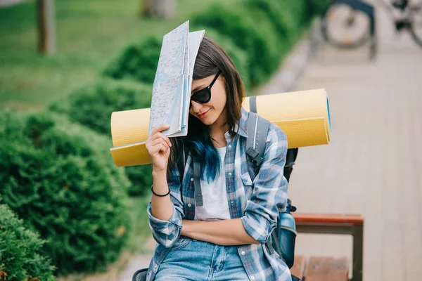 Joven mochilera en gafas de sol sosteniendo mapa - foto de stock