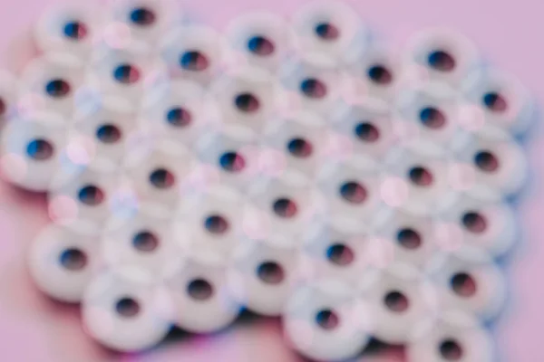 Enfoque selectivo de tuercas de tornillo en superficie rosa - foto de stock