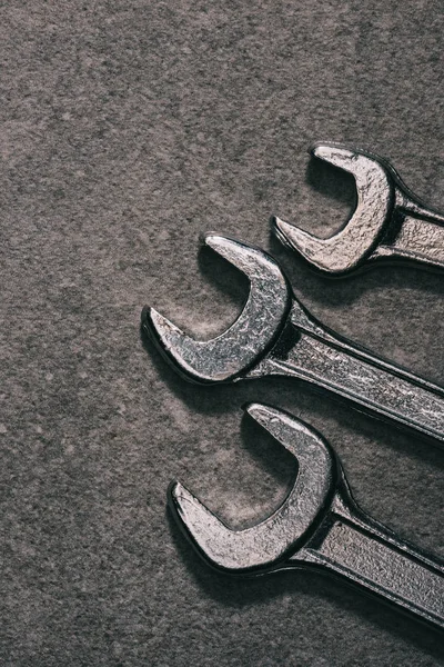 Top view of three metal wrenches on grey surface — Stock Photo