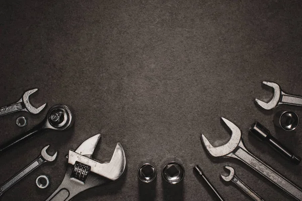 Flat lay with different wrenches, monkey wrench and nuts on grey surface — Stock Photo