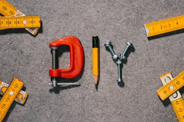Верхний вид слова diy из инструментов на серой поверхности — стоковое фото