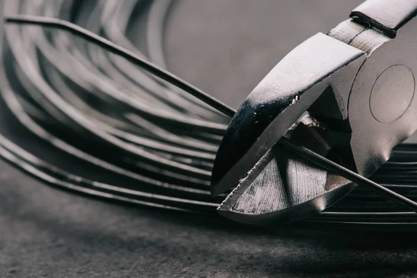 Selective focus of pliers cutting wires on tabletop — Stock Photo