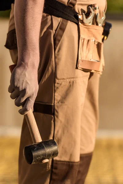Частковий вид будівельника в уніформі тримаючого молотка — стокове фото