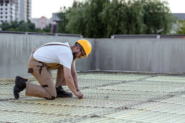 Seitenansicht des Bauarbeiters mit Schutzbrille und harter Arbeit auf der Baustelle — Stockfoto