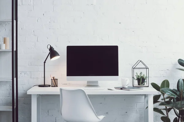 Computadora, mesa blanca, silla y plantas en el lugar de trabajo moderno - foto de stock