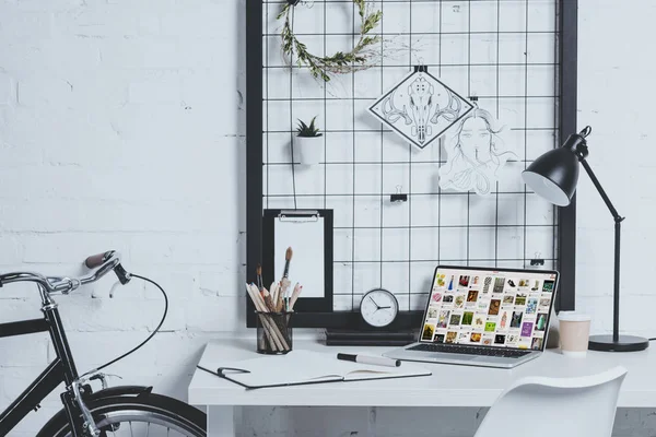 Ноутбук с загруженной страницей pinterest на столе в современном офисе — стоковое фото