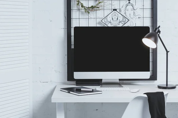 Pantalla de ordenador en blanco en la mesa en la oficina moderna - foto de stock