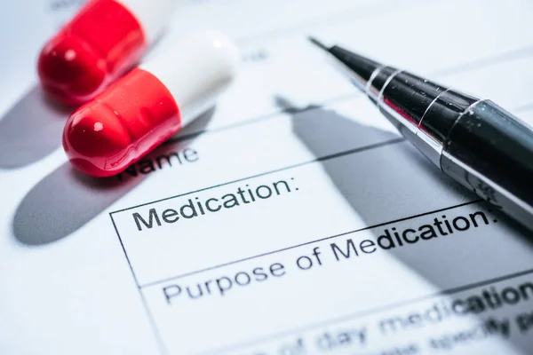 Nahaufnahme des medizinischen Fragebogens, der roten Pillen und auf dem Tisch — Stockfoto