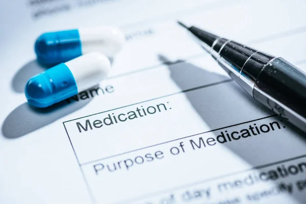 Close up view of medical questionnaire, blue pills and on table — Stock Photo