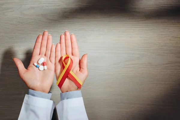Partial view of female doctor holding ribbon and pills, world hepatitis day concept — Stock Photo