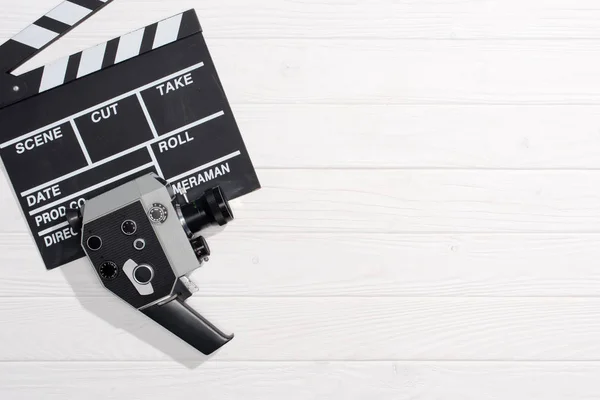 Posa piatta con clapper board e fotocamera retrò su tavolo in legno bianco — Foto stock