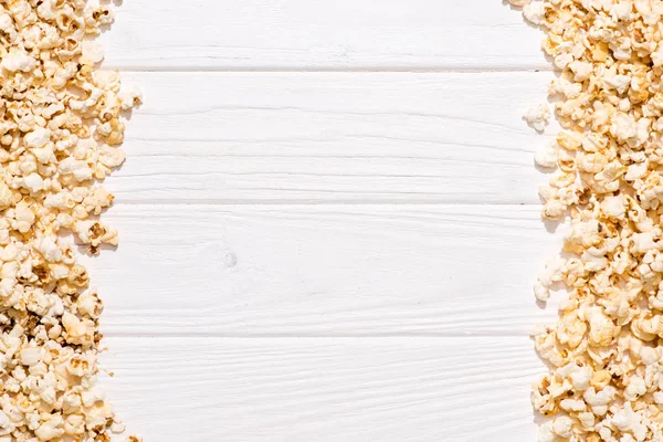 Marco completo de palomitas de maíz dispuestas sobre mesa de madera blanca - foto de stock