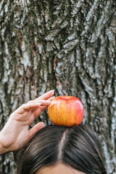 Partial view of girl holding with apple on head — Stock Photo