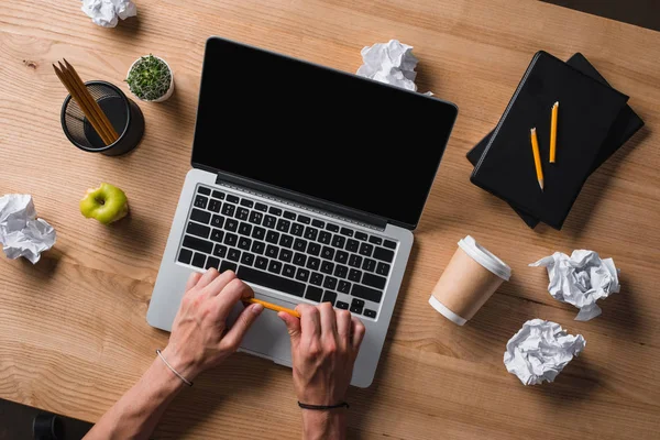 Cropped shot of stressed businessman with pencil sitting at workplace — Stock Photo