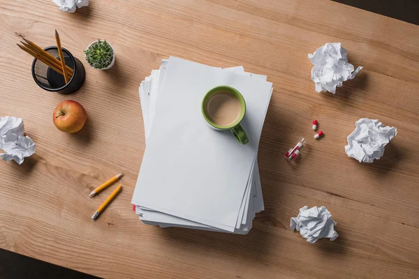 Top view of stacked blank papers with cup of coffee on top on wooden table — Stock Photo