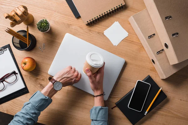 Recortado disparo de empresario con taza de papel de café en el lugar de trabajo - foto de stock