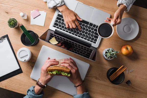 Обрізаний знімок бізнесменів, які обідали на робочому місці — стокове фото