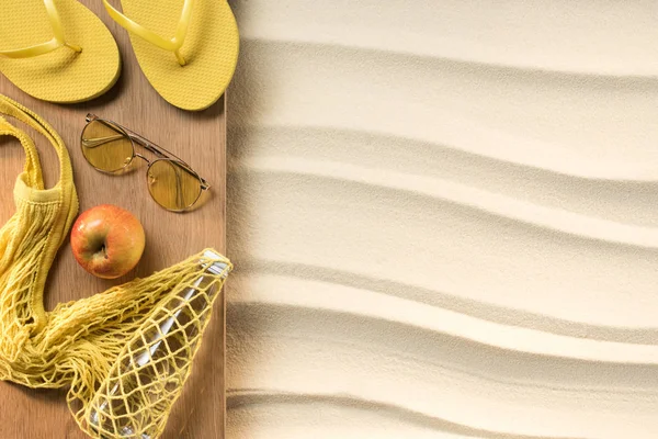 Flat lay with feminine yellow accessories for rest on beach on sand — Stock Photo