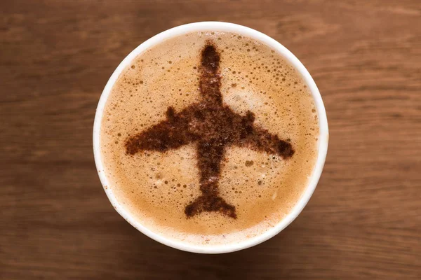 Vista superior da xícara de café com sinal de avião na mesa de madeira, conceito de viagem — Fotografia de Stock