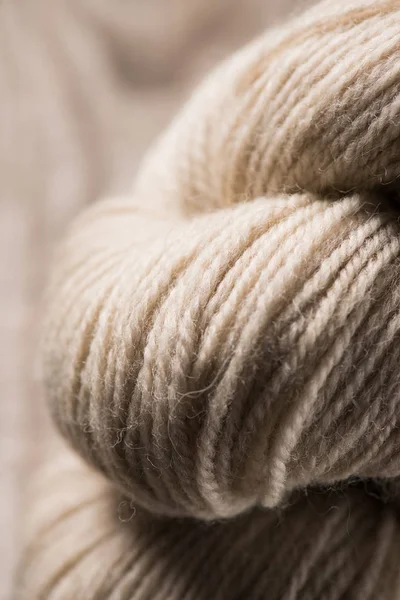 Messa a fuoco selettiva di beige maglia palla filato di lana su sfondo di legno — Foto stock