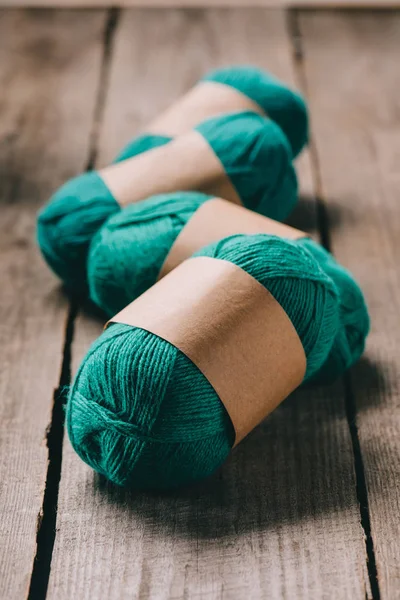 Selective focus of wrapped green knitted yarn on wooden background — Stock Photo