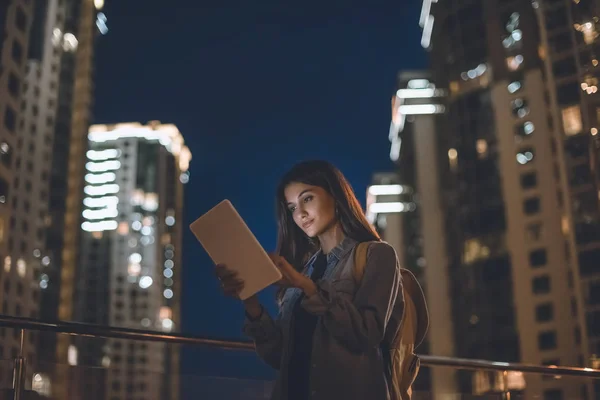 Vue latérale de la femme attrayante en utilisant une tablette numérique sur la rue de la ville la nuit — Photo de stock