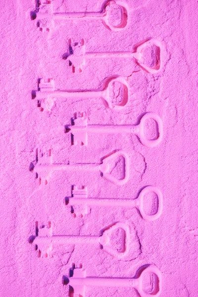 Forme di chiavi su texture in polvere di colore rosa — Foto stock