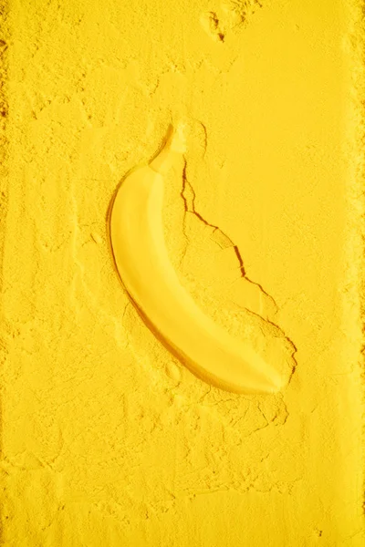 Вид сверху на форму банана в ярко-желтом порошке — стоковое фото