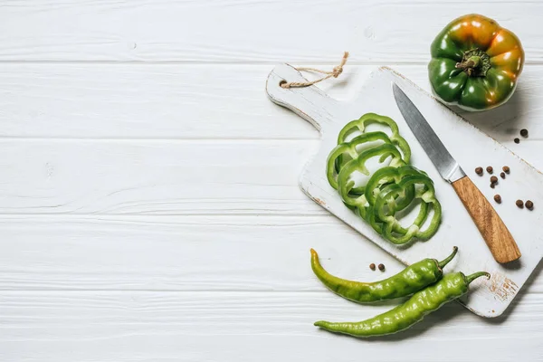 Top view of chili and bell peppers on white wooden table — Stock Photo