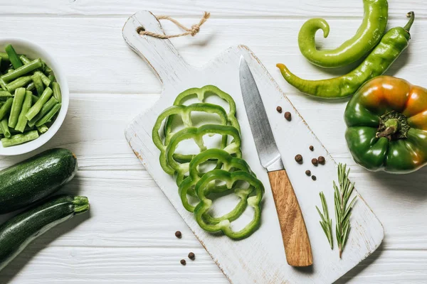 Top view of cut green bell pepper on white wooden cutting board — Stock Photo