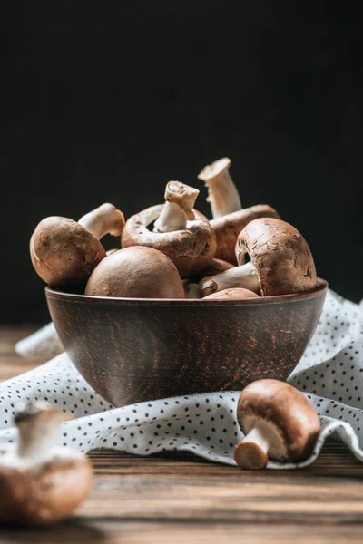 Cogumelos champignon maduros em tigela na mesa de madeira isolada em preto — Fotografia de Stock
