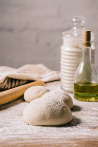 Selective focus of raw dough for pizza and ingredients on tabletop — Stock Photo