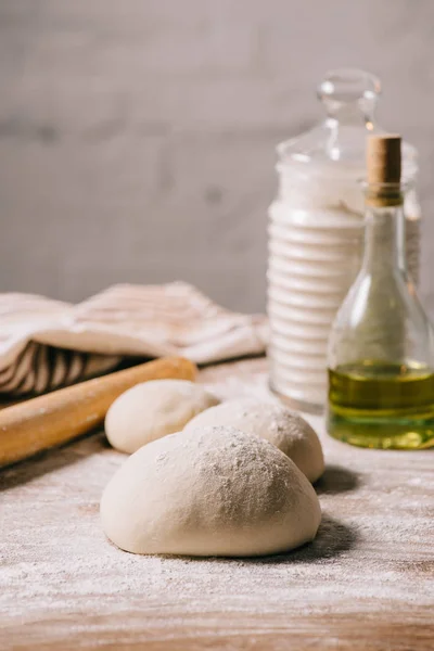 Messa a fuoco selettiva di pasta cruda per pizza e ingredienti su tavolo — Foto stock