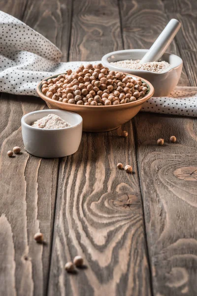 Close up view of raw chickpeas, spices and garlic (hummus ingredients) on wooden tabletop — Stock Photo