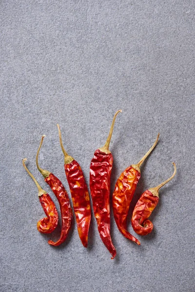 Top view of red chili peppers arranged on grey tabletop — Stock Photo