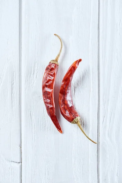 Top view of chili peppers on white wooden surface — Stock Photo